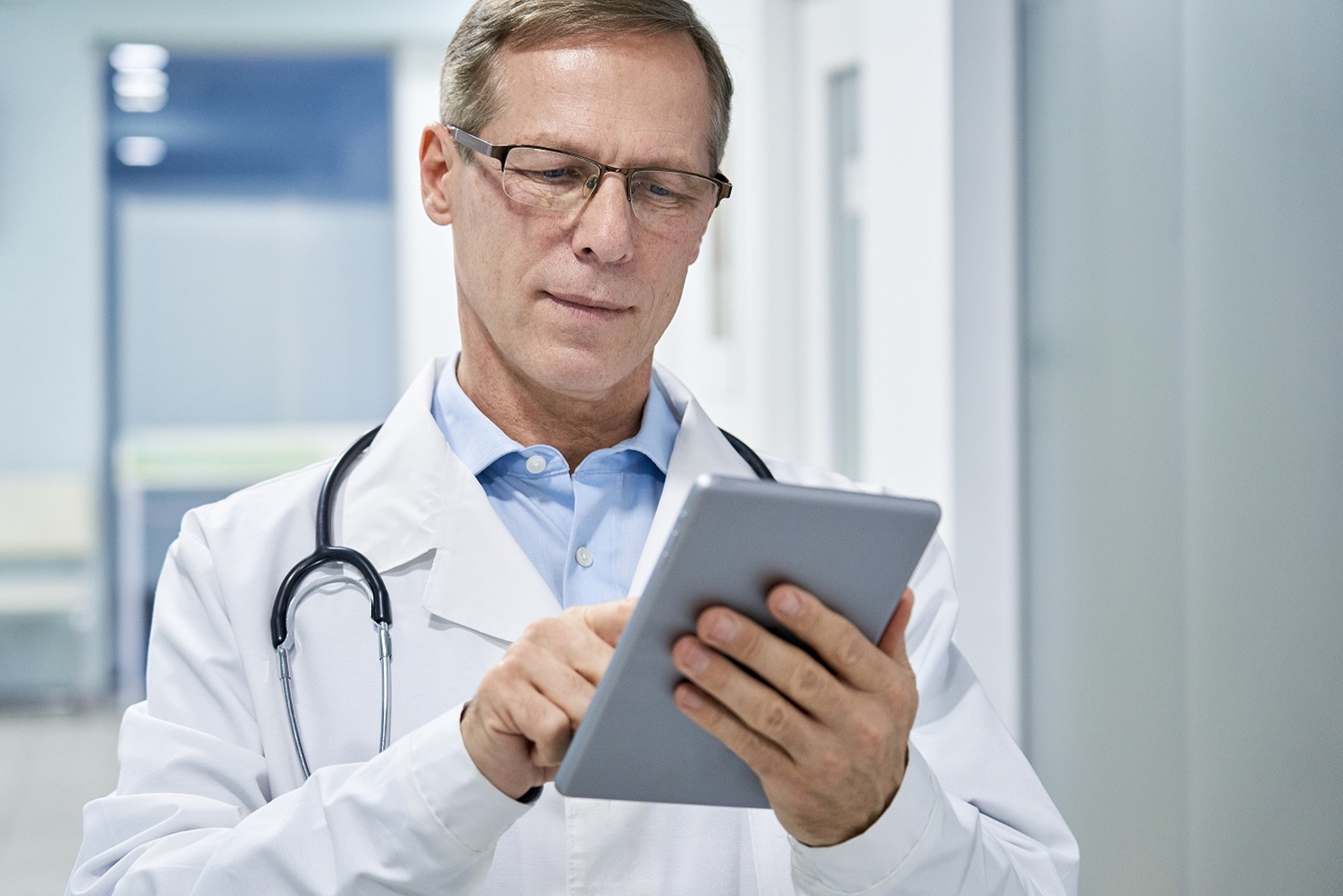 male doctor holding a digital tablet and using industry-specific software technology for medical healthcare